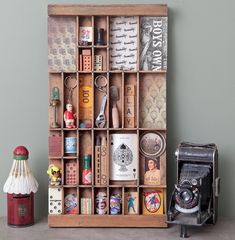 an old fashioned camera sitting on top of a wooden shelf