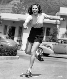 a woman riding a skateboard down a street