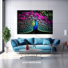 a living room with a blue couch and large painting on the wall above it that has a peacock displaying its colorful feathers