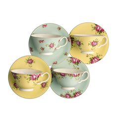 four tea cups and saucers with pink flowers on green, yellow and blue plates