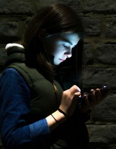 a woman is looking at her phone in the dark