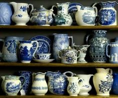 many blue and white vases are on shelves