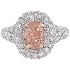 a fancy pink diamond ring set in 18k white and yellow gold with diamonds surrounding it