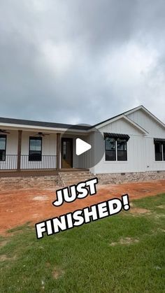 a house with the words just finished in front of it and an overcast sky