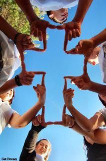 a group of people standing in a circle with their hands together