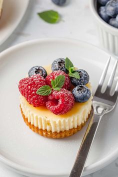 there is a small dessert on the plate with blueberries and raspberries in it