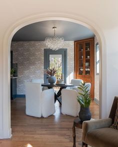 an archway leads into the dining room and living room, which is decorated in white