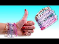 a woman's hand holding several bracelets in different colors and designs, with the thumb pointing up