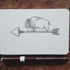 a notebook with a drawing of a buffalo on it and an arrow in the middle