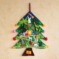 a christmas tree made out of paper with animals and trees on it's sides