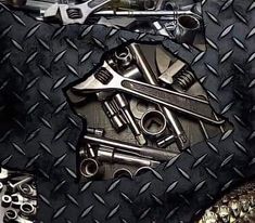 several different types of tools on a diamond plate pattern with the words mechanic's cut above them