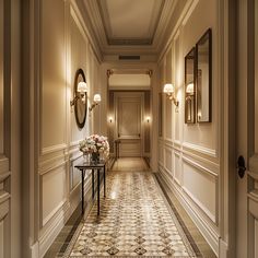 the hallway is lined with elegant wall sconces, mirrors and vases filled with flowers