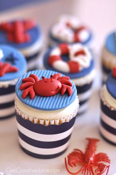 cupcakes decorated with red and blue icing are sitting on a white table