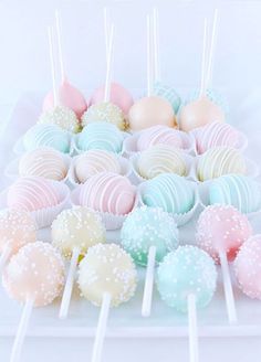 there are many different colored cake pops on the table