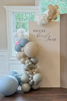 balloons are stacked on top of each other in front of a sign