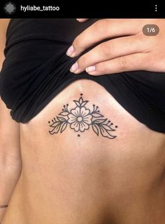 a woman's stomach with a flower tattoo on her belly and the bottom part of her abdomen