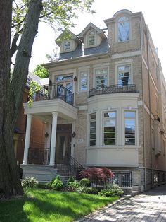 a large two story house with many windows and balconies on the second floor