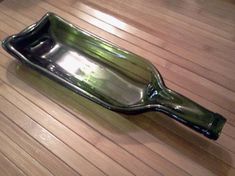 an empty glass bottle sitting on top of a wooden table