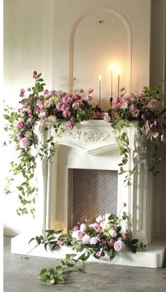 a mantel with flowers and candles on it