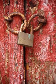 a padlock attached to an old red door