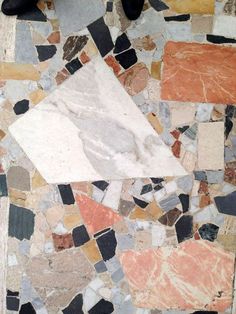 a white piece of paper sitting on top of a pile of colorful rocks and stones