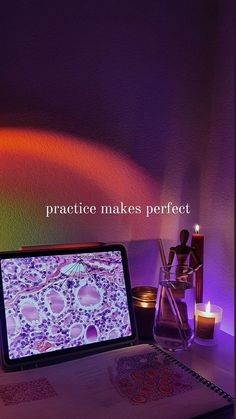 a laptop computer sitting on top of a desk next to a vase and candle holder