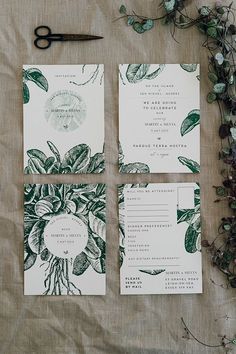 the stationery is laid out on top of the table with scissors and greenery