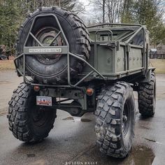 an army truck is parked in the parking lot with its tires on it's flatbed