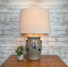 a table with a lamp and potted plant on it