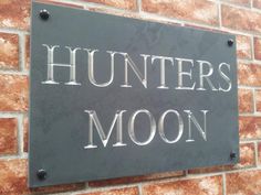 a sign on the side of a brick building that says hunters moon written in silver