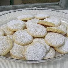 a glass bowl filled with powdered sugar cookies