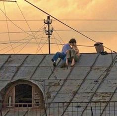 two people sitting on the roof of a building