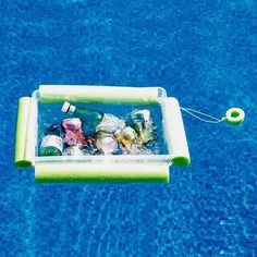 an inflatable pool float filled with bottles and cans floating on the blue water