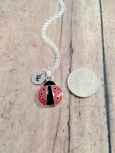 "This listing is for a hand-stamped initial necklace featuring a 7/10\" x 1/2\" silver plated and red enamel ladybug charm & 3/10\" stainless steel initial pendant. The silver plated chain is 18\" long, but can be made to your desired length- see last photo in listing for length guide. Please indicate the chain length you would like in the 'notes to seller' section at checkout. All items are lead & nickel free. Message me with any questions, thank you! Add an initial to any necklace http Cute Red Round Jewelry, Cute Round Red Jewelry, Dainty Personalized Red Charm Necklaces, Dainty Red Personalized Charm Necklaces, Red Personalized Dainty Necklace, Dainty Red Personalized Necklaces, Dainty Personalized Red Necklaces, Personalized Red Dainty Necklace, Adjustable Red Personalized Necklace