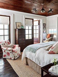 a bed sitting in a bedroom next to two chairs