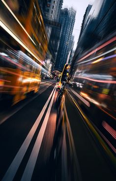 an image of a city street with blurry cars going by in the night time