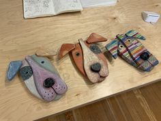 three ceramic dogs sitting on top of a wooden table