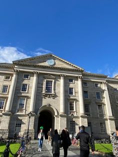 people walking in front of an old building