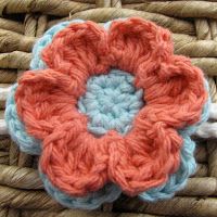 a crocheted flower on top of a woven basket