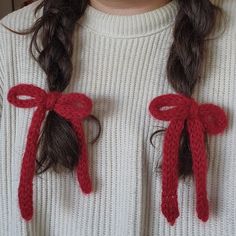 a close up of a person wearing a sweater with two bows on it's back