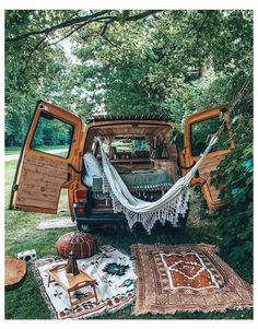 an image of a car with hammocks in the back and other items on the ground