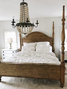 a bedroom with a bed, dresser and chandelier