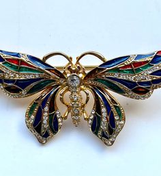 Stunning Jackie Bouvier Kennedy (JBK) pin.  A collection of Jackie Kennedys jewelry has been reproduced this being one of them. Pin is made of jewelry alloy of gold tone, decorated with transparent crystals and multi colored sparkling enamels. The wings are colorful shiny enamels of red, blue, green and clear Austrian crystals. Beautiful pin, no missing crystals, no marks,dents,or scratches.  Please see all photos,zoom in for fine details. Back is marked JBK on one side, China on the other. Multicolor Butterfly Brooch Jewelry, Jackie Bouvier, Green Aventurine Stone, Crystals Beautiful, Aventurine Stone, Butterfly Pin, Faux Pearl Necklace, Red Blue Green, Jade Beads