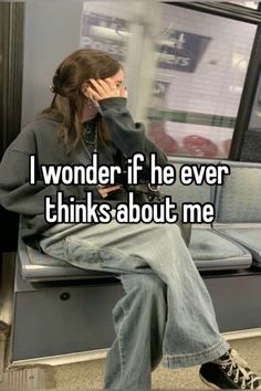 a woman sitting on a subway train talking on her cell phone with the caption i wonder if he ever thinks about me