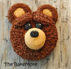 a cake shaped like a teddy bear on top of a wooden table with the words, the bakermore