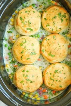 several rolls in a pot filled with broccoli and other vegetables, garnished with parsley