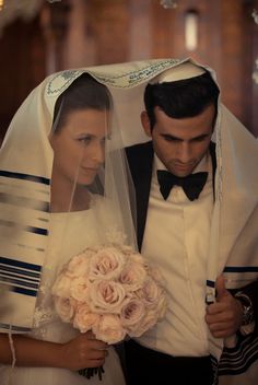 the bride and groom are dressed in traditional greek garb, with veils over their heads