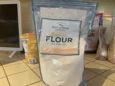 a bag of flour sitting on top of a kitchen counter next to a computer monitor