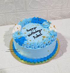 a birthday cake with blue frosting and gold sprinkles