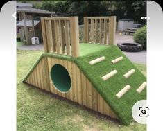 a wooden play structure with grass on top